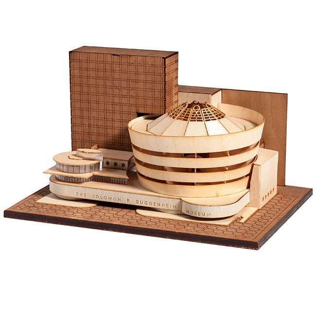 The Guggenheim Architectural Model Kit is a wooden replica of New York’s iconic spiral-shaped Solomon R. Guggenheim Museum, including flat-roofed structures and engraved text on the base.