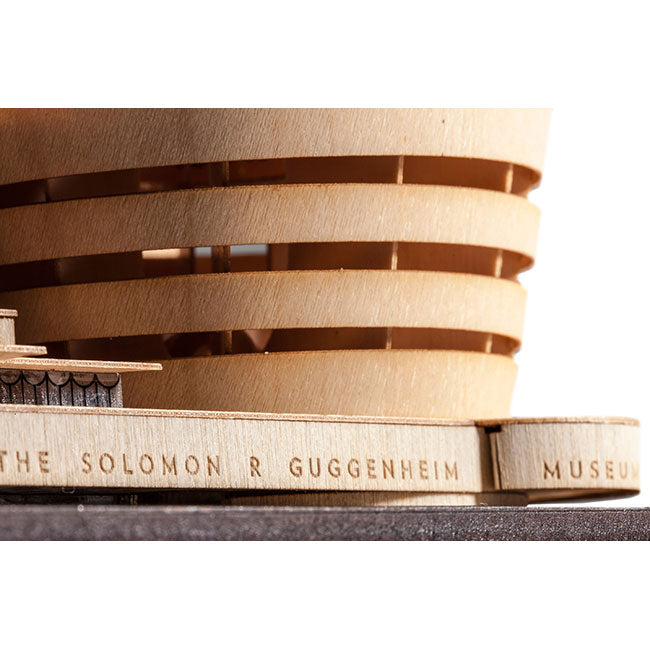 Close-up of the Guggenheim Architectural Model Kit, showing curved, layered wooden walls and THE SOLOMON R GUGGENHEIM MUSEUM engraved on the base—honoring this legendary New York City landmark.