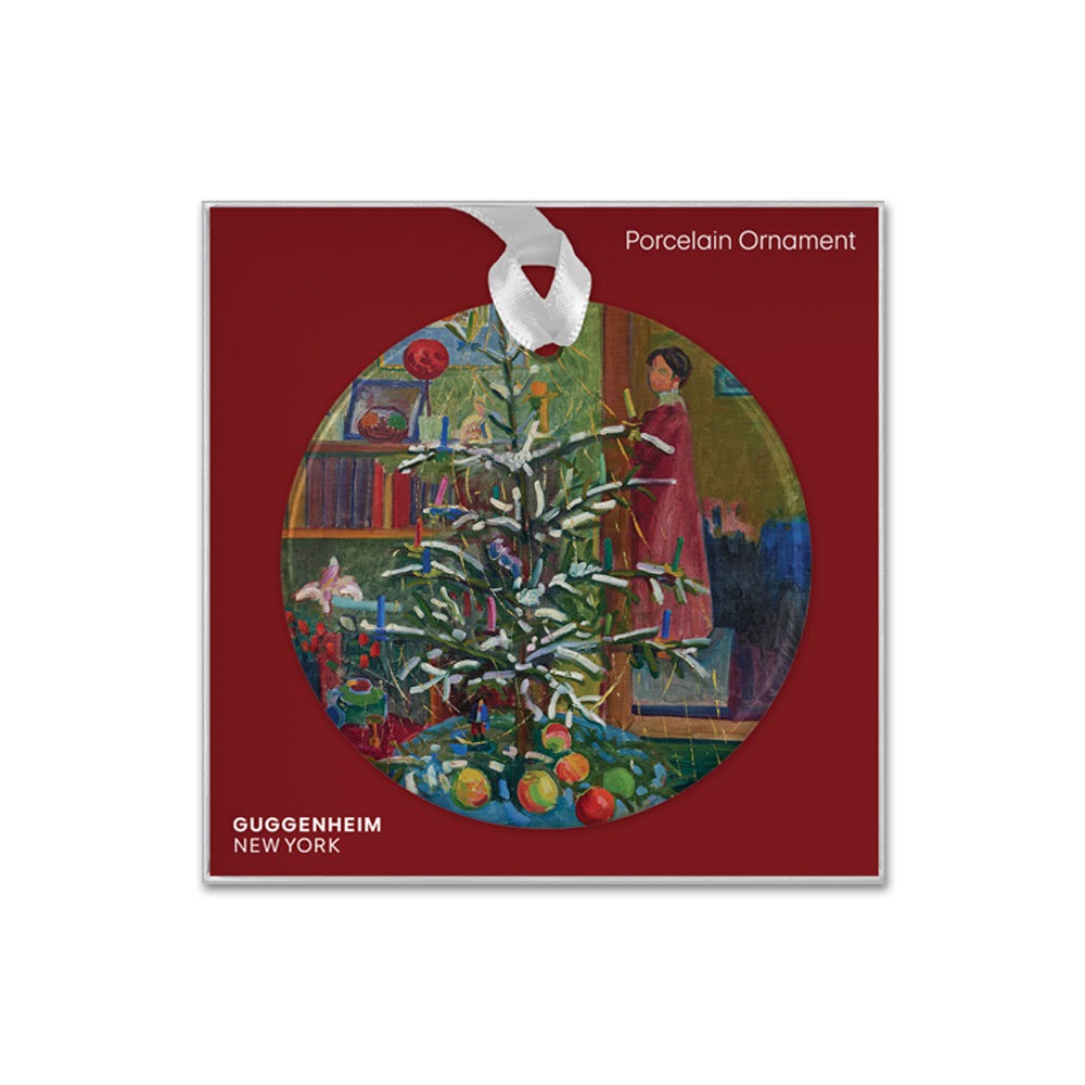 The Gabriele Münter, Christmas Still Life Ornament is a round porcelain piece featuring a painted tree with candles, fruit, and a figure in red. It hangs from a white ribbon and has “Guggenheim New York” on a deep red background.