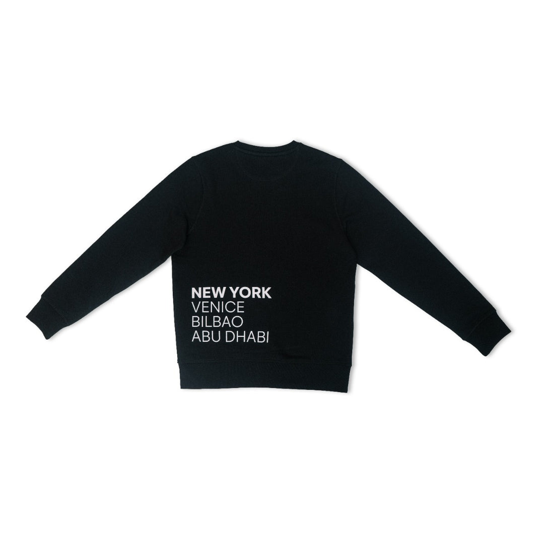 The Guggenheim Constellation Crewneck Sweatshirt, New York Black, features white text—NEW YORK, VENICE, BILBAO, ABU DHABI—vertically on the lower left back. Perfect for art lovers seeking iconic institution style.
