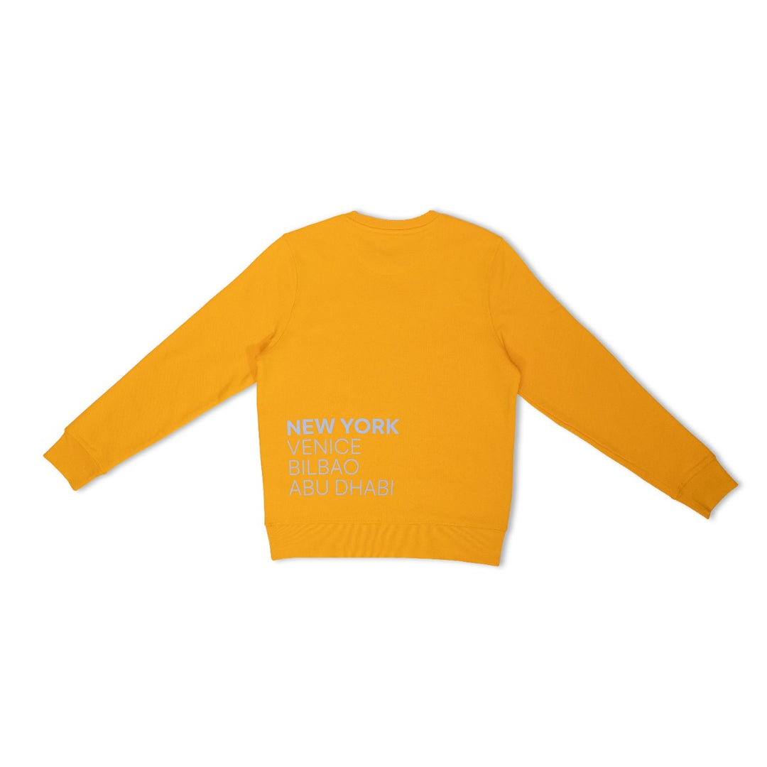 A yellow Guggenheim Constellation Crewneck Sweatshirt is displayed flat, showing the back with white text listing cities—NEW YORK, VENICE, BILBAO, ABU DHABI—in the lower right corner.