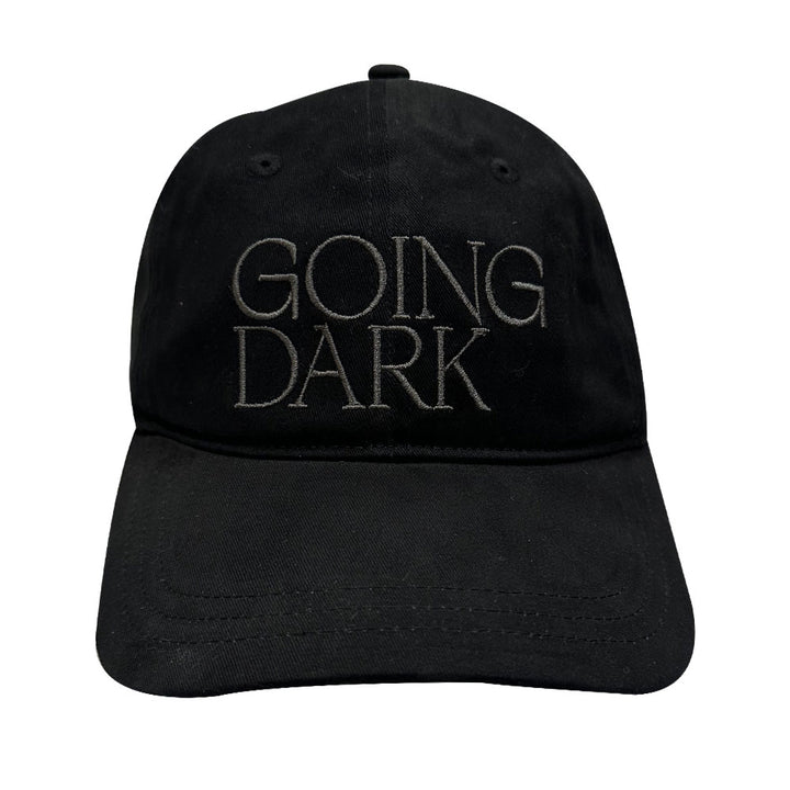 A black cotton Guggenheim Going Dark Logo Cap featuring "GOING DARK" embroidered in large, light gray letters on the front, inspired by contemporary artists.