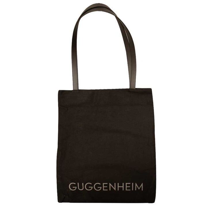 The Guggenheim "Go Dark" Tote is a limited edition black bag with two handles and "GUGGENHEIM" printed in light letters at the bottom—ideal for contemporary art fans.