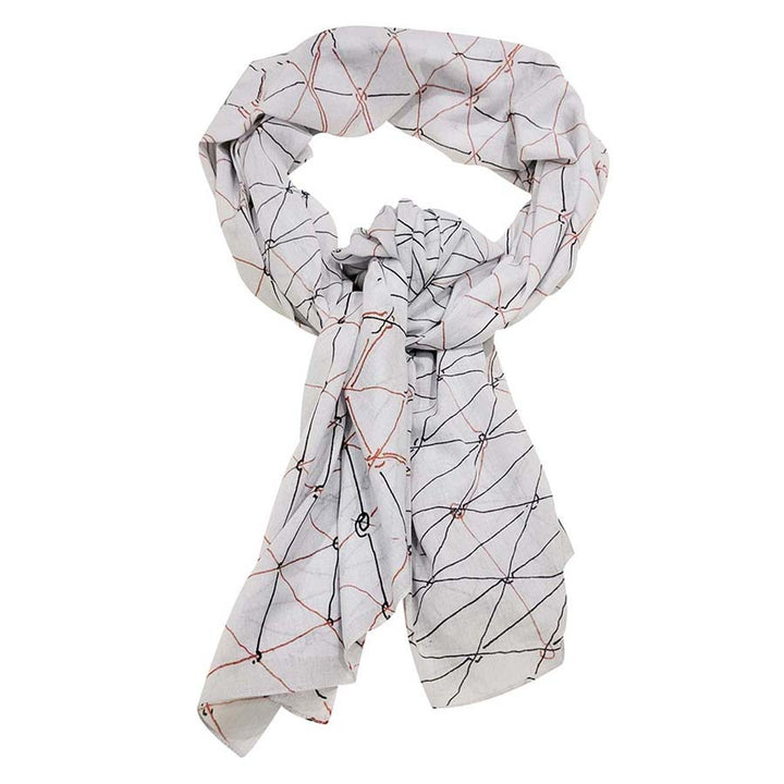 A light gray Gego Scarf, Cotton Oblong, features intersecting red and black lines forming geometric shapes inspired by the Measuring Infinity exhibition at the Guggenheim Museum, shown here loosely knotted.