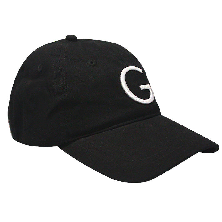 The Guggenheim "G" Cap is a black cotton adjustable baseball cap featuring a white embroidered "G" on the front, shown against a white background.