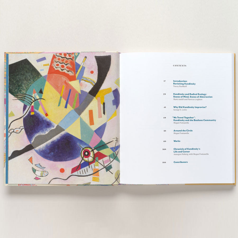 An open book titled Vasily Kandinsky: Around the Circle displays a colorful geometric abstract painting inspired by Bauhaus on the left and a table of contents with blue text on the right page.