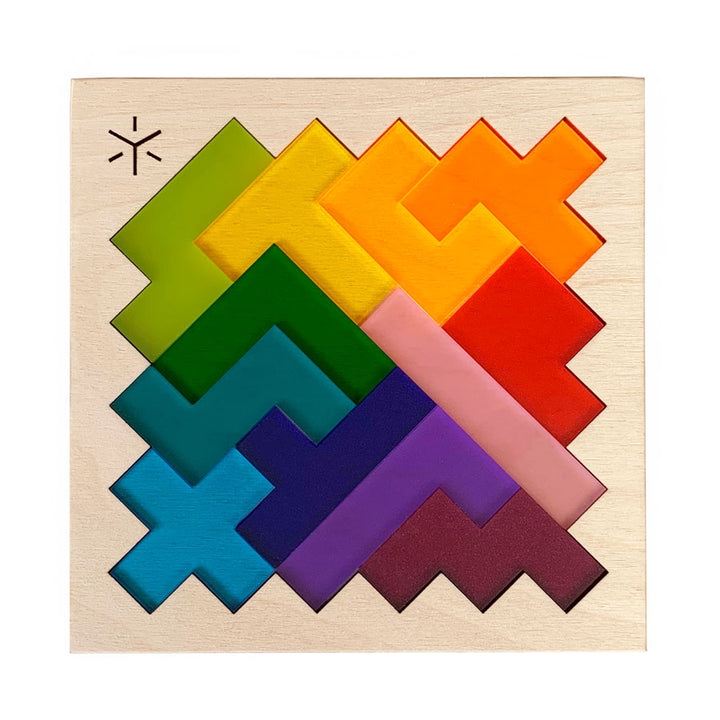 The Rainbow Pentomino Puzzle features zigzag-shaped wooden pieces in green, yellow, orange, red, pink, purple, and blue that fit together in a square frame—a vibrant coffee table challenge for puzzle fans.